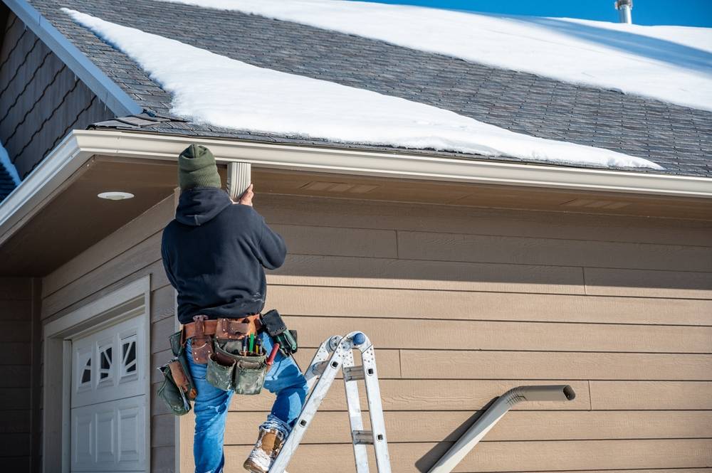 Contractor,Installing,Gutters,On,A,Residential,Building,In,The,Winter